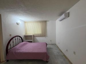 a bedroom with a bed with a purple blanket at Casa Arabesca in Acapulco +2 photos
