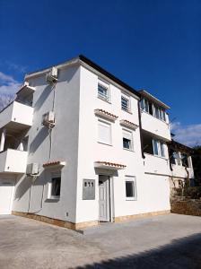 a white building with a lot of windows at Jakišnica Apartment in Lun