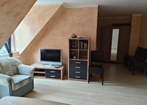 a living room with a couch and a television at Fewo Steuerboard in Röbel