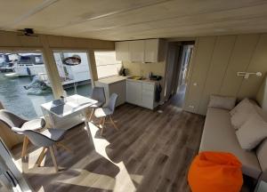 a small kitchen and living room in a tiny house at Hausboot Emma Blue in Röbel