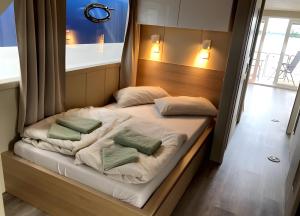a bed in a room with two pillows on it at Hausboot Emma Blue in Röbel