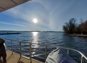 a boat on a body of water with the sun in the sky at Hausboot Emma Blue in Röbel