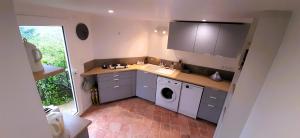 a kitchen with a sink and a washing machine at La petite maison d'Hose in Monistrol-sur-Loire