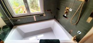 a large white tub in a bathroom with a window at La petite maison d'Hose in Monistrol-sur-Loire +27 photos