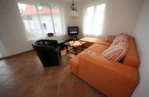 a living room with an orange couch and a table at Haus u8 in Röbel