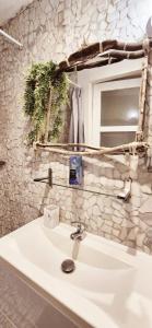 a white sink in a bathroom with a stone wall at Garaztegia Studio in Ustaritz
