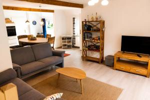 a living room with a couch and a tv at Haus Königsfeld in Hage