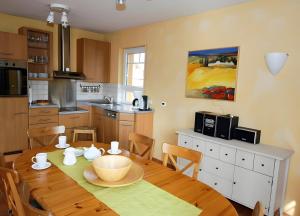 a kitchen with a wooden table and a dining room at Haus 12 in Röbel