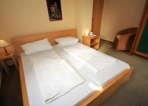 a bedroom with a bed with white sheets and pillows at Haus 12 in Röbel