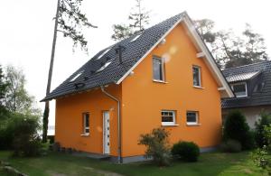 a small orange house with a black roof at Haus 12 in Röbel
