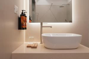 a bathroom with a large white bowl on a counter at IONE Suites in Preveza +47 photos