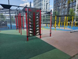 a playground with red and yellow equipment in a city at Fayna Town Comfort #2 in Kyiv