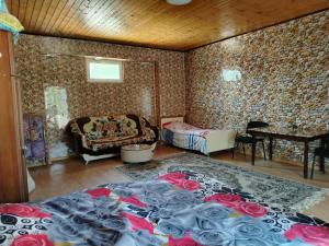 a room with a bed and a table with roses on it at good house in Quba