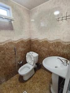 a bathroom with a toilet and a sink at good house in Quba