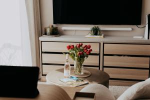 a living room with a vase of flowers and a tv at Saturn Studio by Navie Stays in Poole