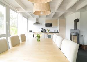 a dining room with a long table and white chairs at Haus W 7 in Röbel +11 photos