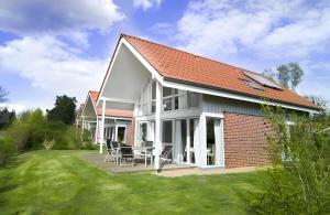 a white house with a red roof at Haus W 7 in Röbel