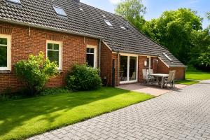 a brick house with a table and chairs in the yard at Haus Königsfeld in Hage
