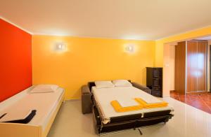 een slaapkamer met 2 bedden en een gele muur bij Apartments Mika in Budva