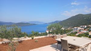 Ein Tisch und Stühle auf einem Balkon mit Blick auf das Wasser in der Unterkunft Apartman Intrada in Neum