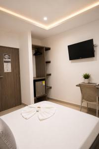 a room with a bed and a tv on the wall at Hotel Don Felipe in Ríohacha