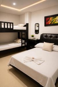 a bedroom with two beds and two bunk beds at Hotel Don Felipe in Ríohacha +12 photos
