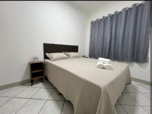 a bedroom with a bed with two towels on it at Executivo Central 102 in Ipatinga
