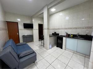 a living room with a couch and a kitchen at Executivo Central 102 in Ipatinga