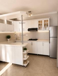 a white kitchen with a sink and a refrigerator at SAkura Hotel Astara in Astara