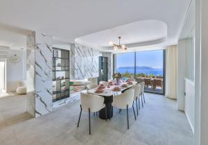 a dining room and living room with a table and chairs at Villa Sky Line - Private Pool - Panoramic Sea View in Kaş