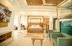 a bedroom with a bed and two green chairs at 36 Palms- Sun and Sand in Cochin