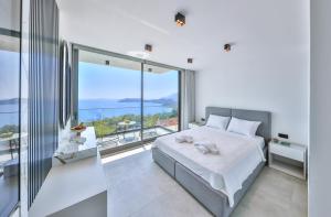 a bedroom with a bed and a large window at Villa Sky Line - Private Pool - Panoramic Sea View in Kaş +29 photos