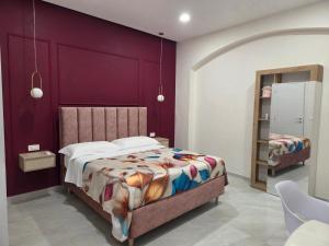 a bedroom with a bed and a purple wall at Suite in centro in Aversa +18 photos