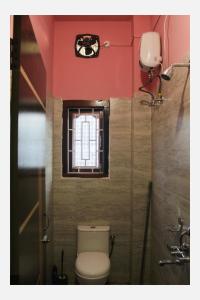 a bathroom with a toilet and a window at Mini Emphum 2BHK Apartment in Namsai