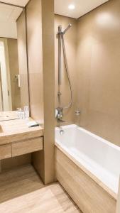 a bathroom with a tub and a sink and a shower at برج داماك الرياض in Riyadh