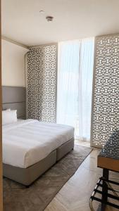 a bedroom with a bed and a large window at برج داماك الرياض in Riyadh