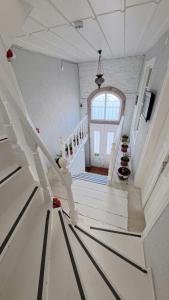 a white staircase in a house with a window at Mimosa House Ayvalık in Ayvalık