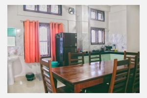 a kitchen with a table and chairs and a refrigerator at Mini Emphum 2BHK Apartment in Namsai