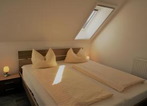 a bedroom with a bed with white sheets and a skylight at Haus U13 in Röbel