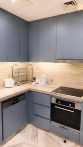 a kitchen with blue cabinets and a counter top at برج داماك الرياض in Riyadh +18 photos