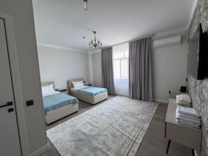 a hotel room with two beds and a television at Zere Motel in Türkistan