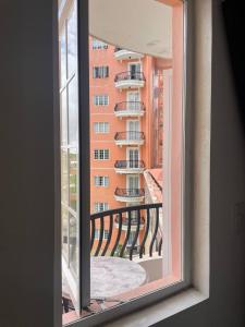 a window with a view of a building at D' Cozy Pines Suites in Baguio