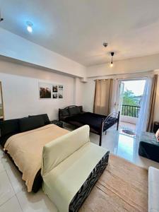 a bedroom with a bed and a living room at D' Cozy Pines Suites in Baguio
