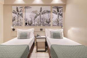 two beds in a hotel room with two beds sidx sidx sidx at Havana Palace Hotel II Uberaba in Uberaba +62 photos
