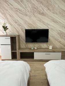a bedroom with a flat screen tv on a wall at Prenoćište Lovac in Prijepolje