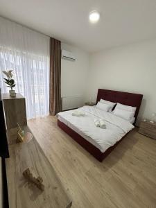 a bedroom with a large bed with white sheets at Prenoćište Lovac in Prijepolje