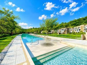 a swimming pool at a apartment complex with trees and buildings at Miramonte Payande in Nimaima