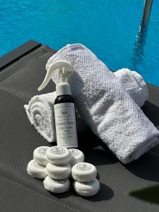 a bottle of mouthwash and four towels next to a pool at Holiday Home Slap Koćuša in Ljubuški +37 photos