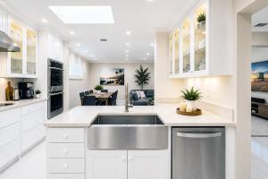 a kitchen with white cabinets and a stainless steel sink at Premium Luxury 5BR Villa near Hollywood Beach in Hollywood