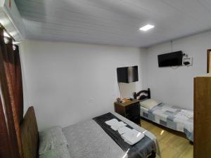 a hotel room with two beds and a tv at Kurten Hotelaria in Cândido de Abreu